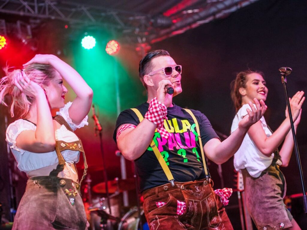 Andreas Gabalier Double Sachsen auf der Bühne mit zwei Tänzerinnen.